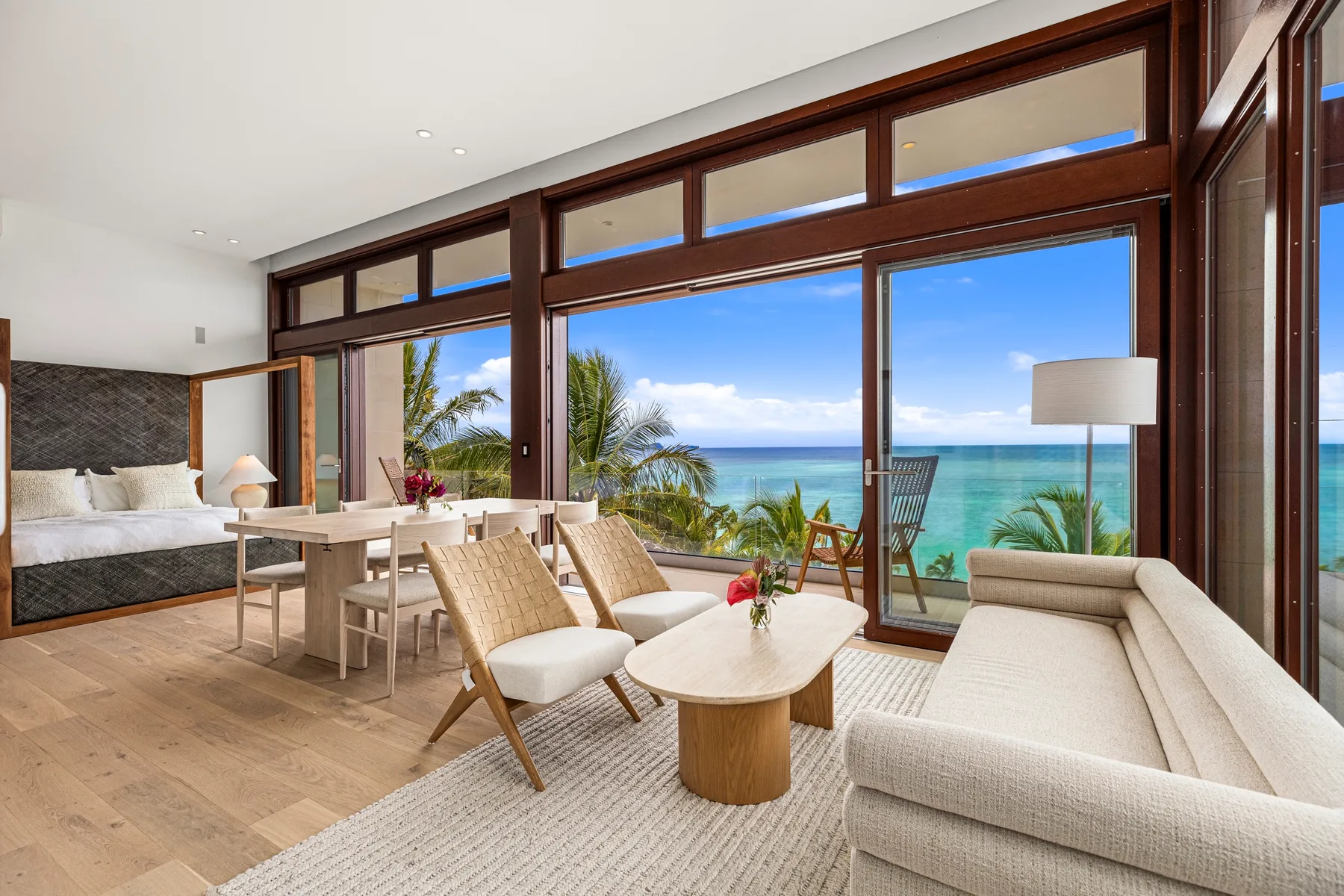 A bright living and dining area opens onto a view of the ocean.