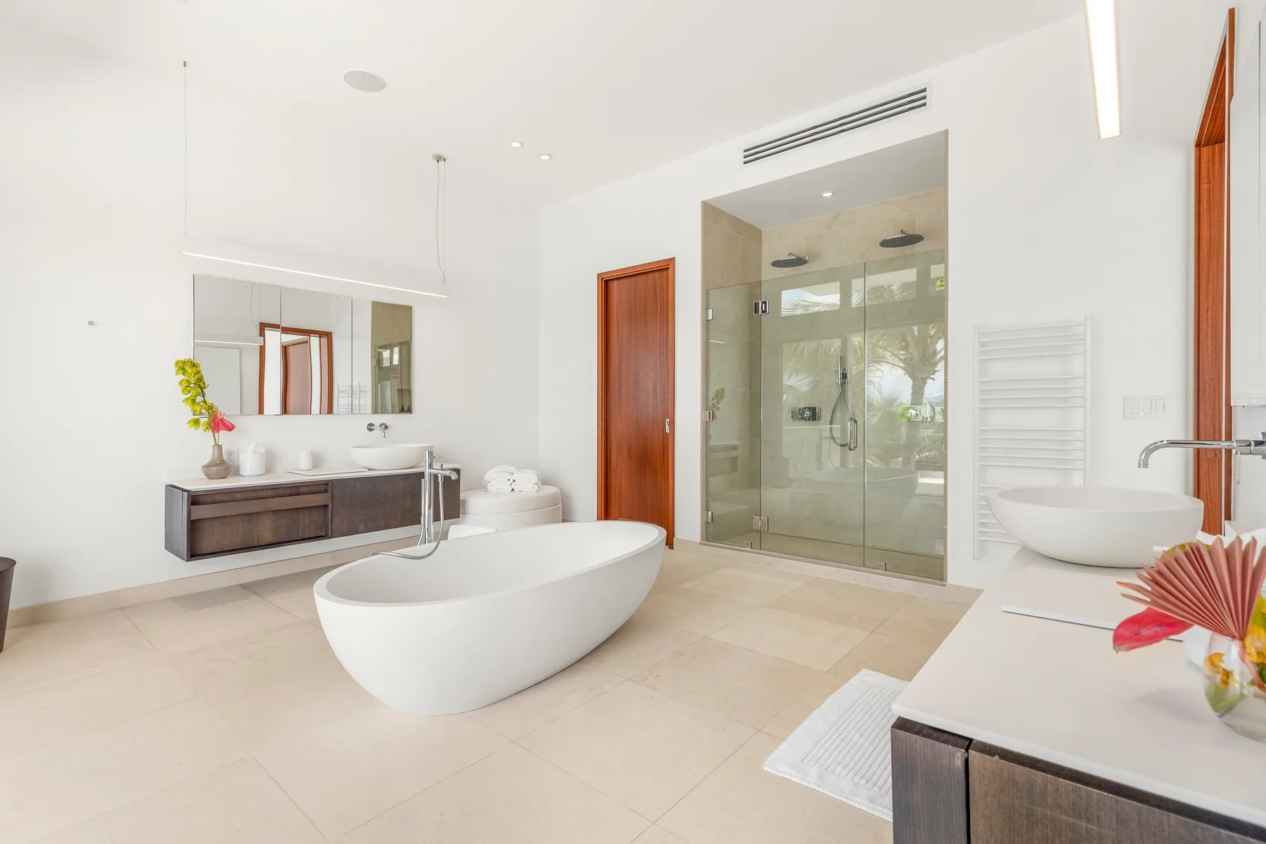 A bright bathroom with a freestanding bathtub and glass shower.