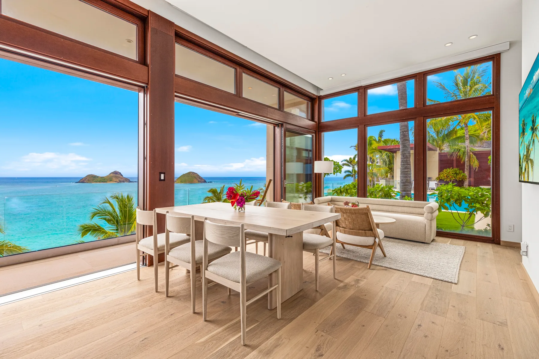 A bright living and dining area with large windows overlooking the ocean.
