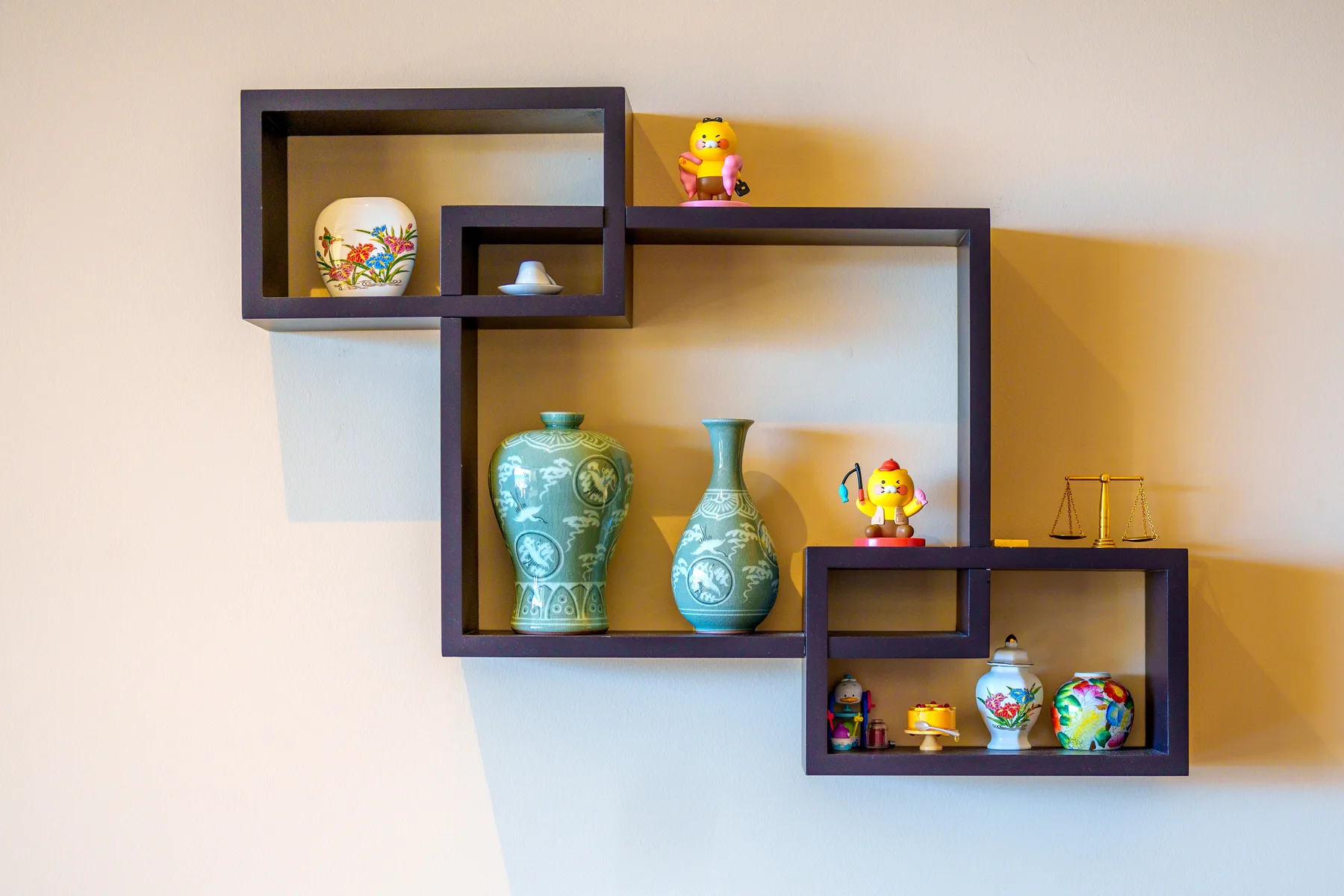 Decorative wall shelves display colorful vases and small figurines.