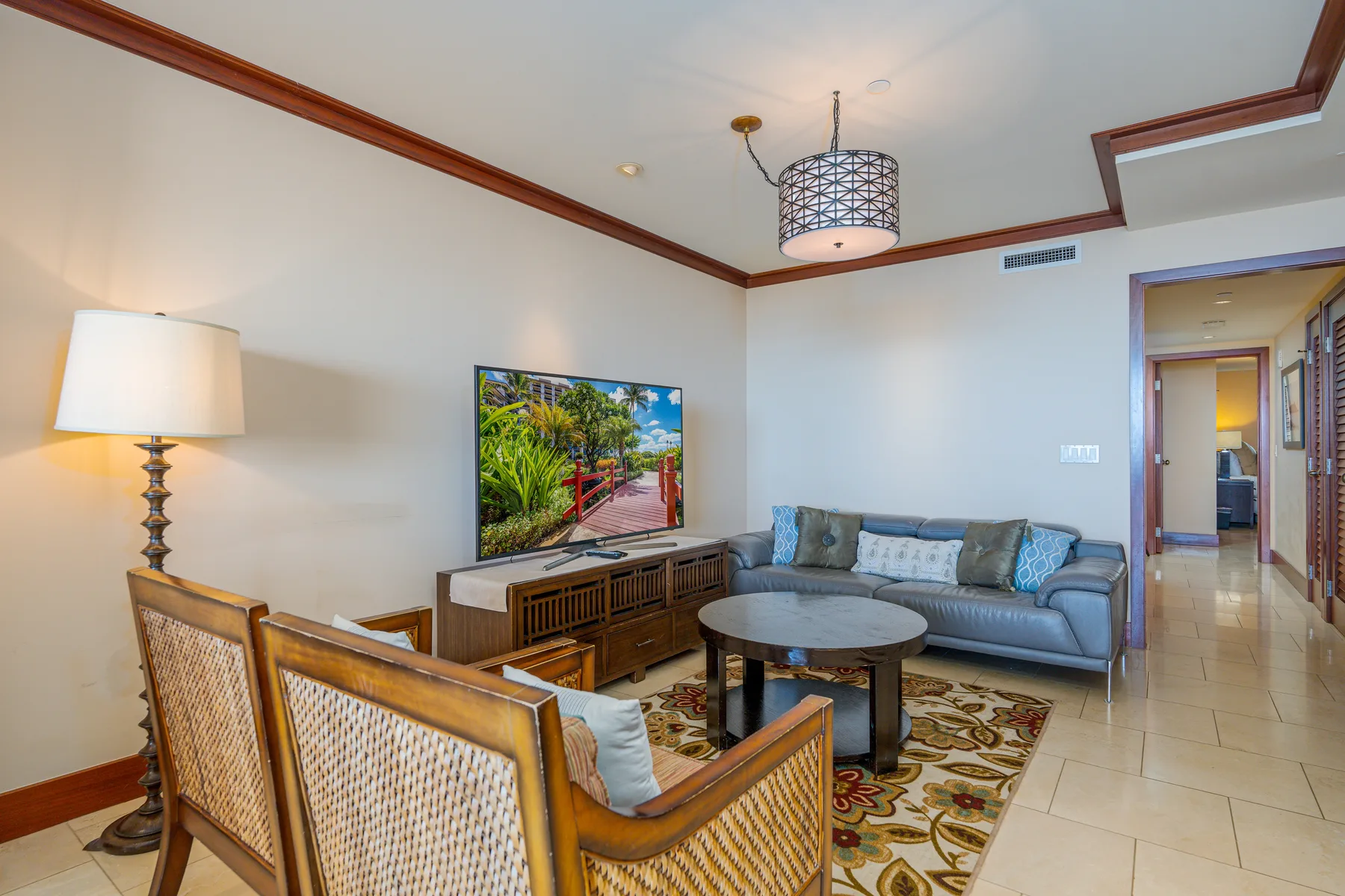 A living room with a sofa, armchairs, and a television.