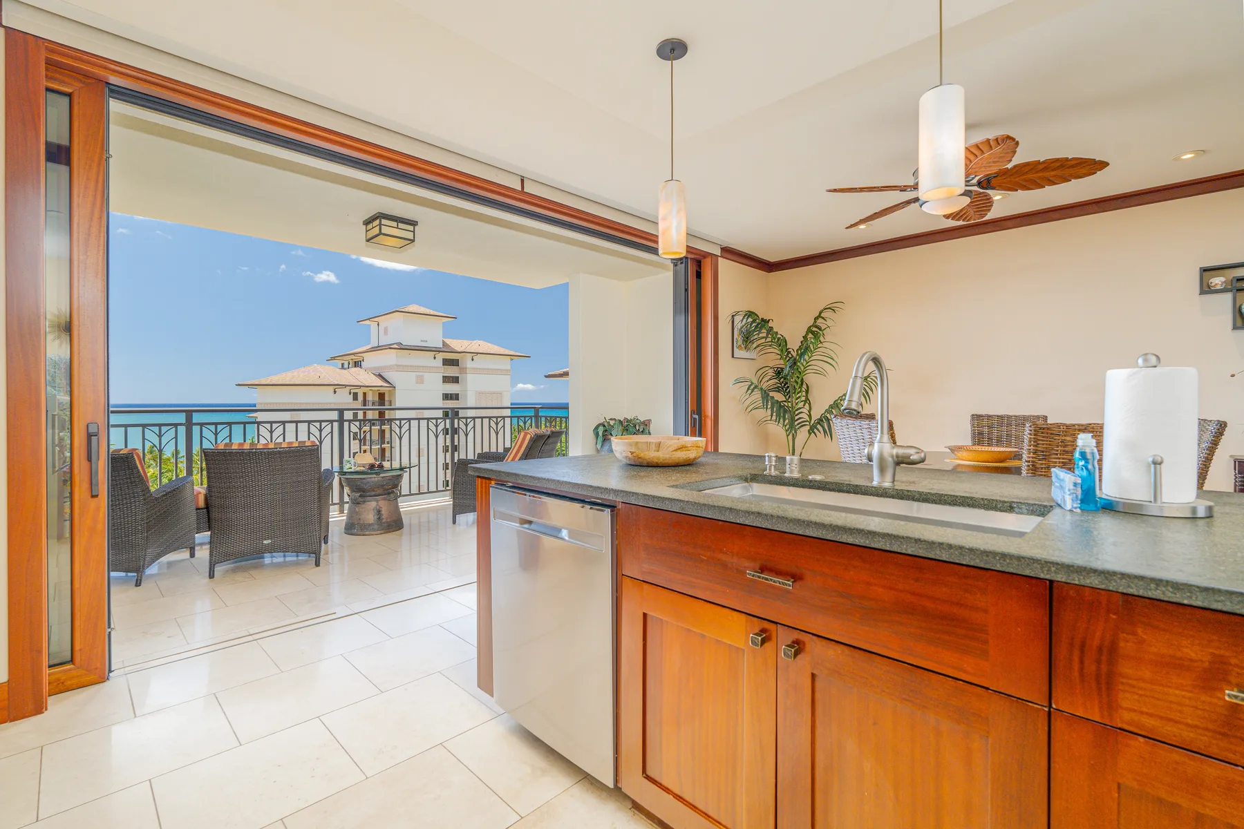 A kitchen opens onto a balcony, with a counter and sink in the foreground.