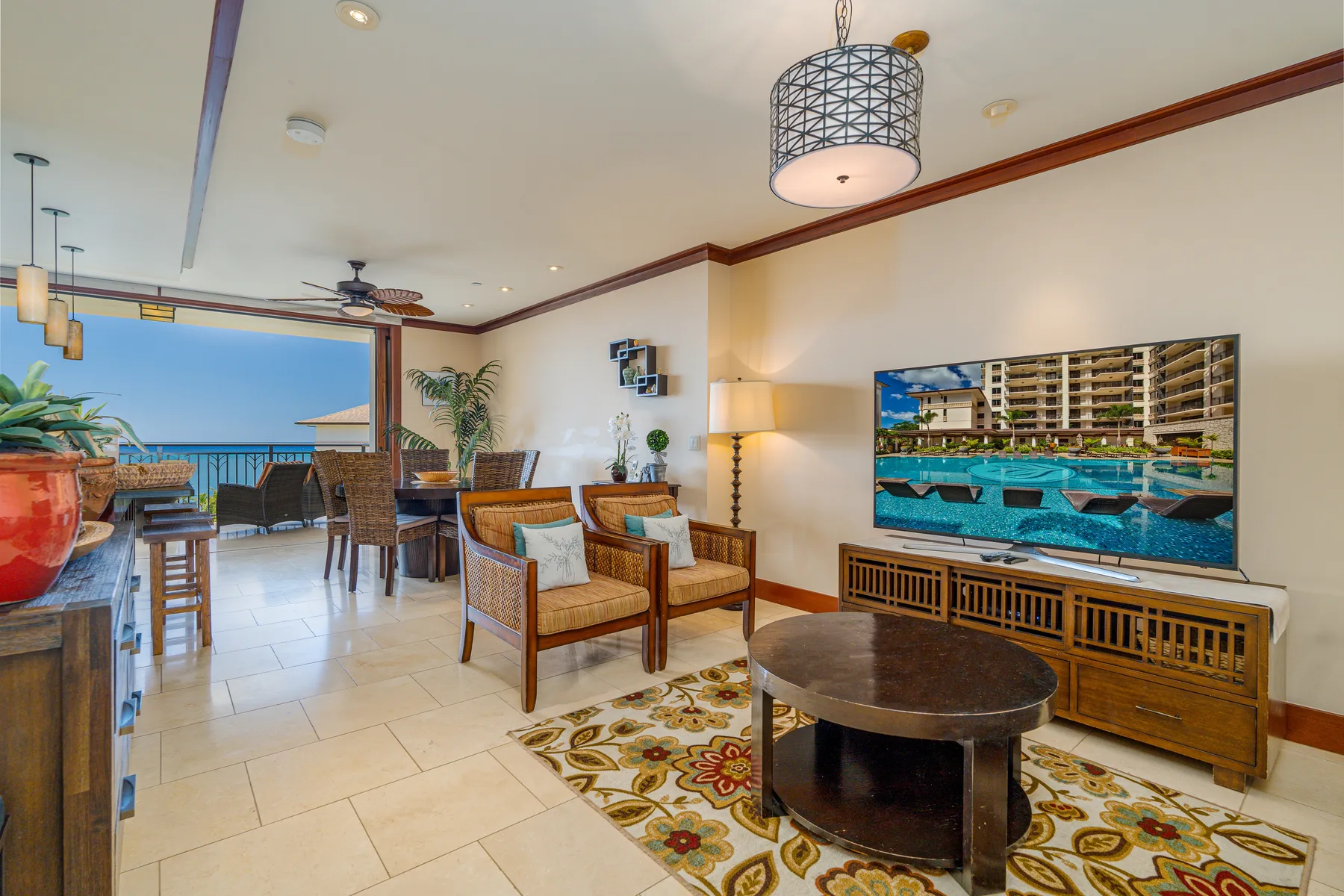 Una sala de estar con asientos, una mesa de centro y un comedor junto a las ventanas.