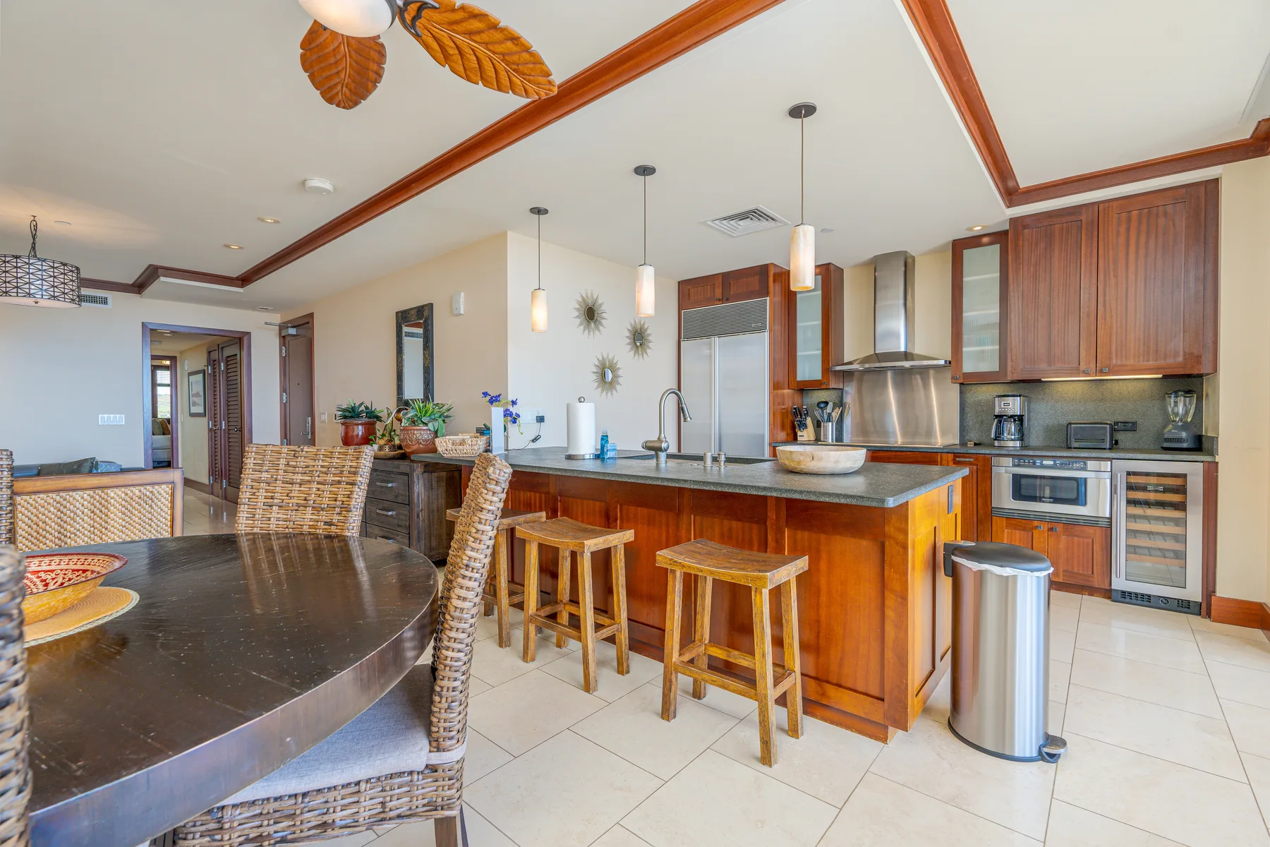 A spacious kitchen with a central island and a dining table in the foreground.