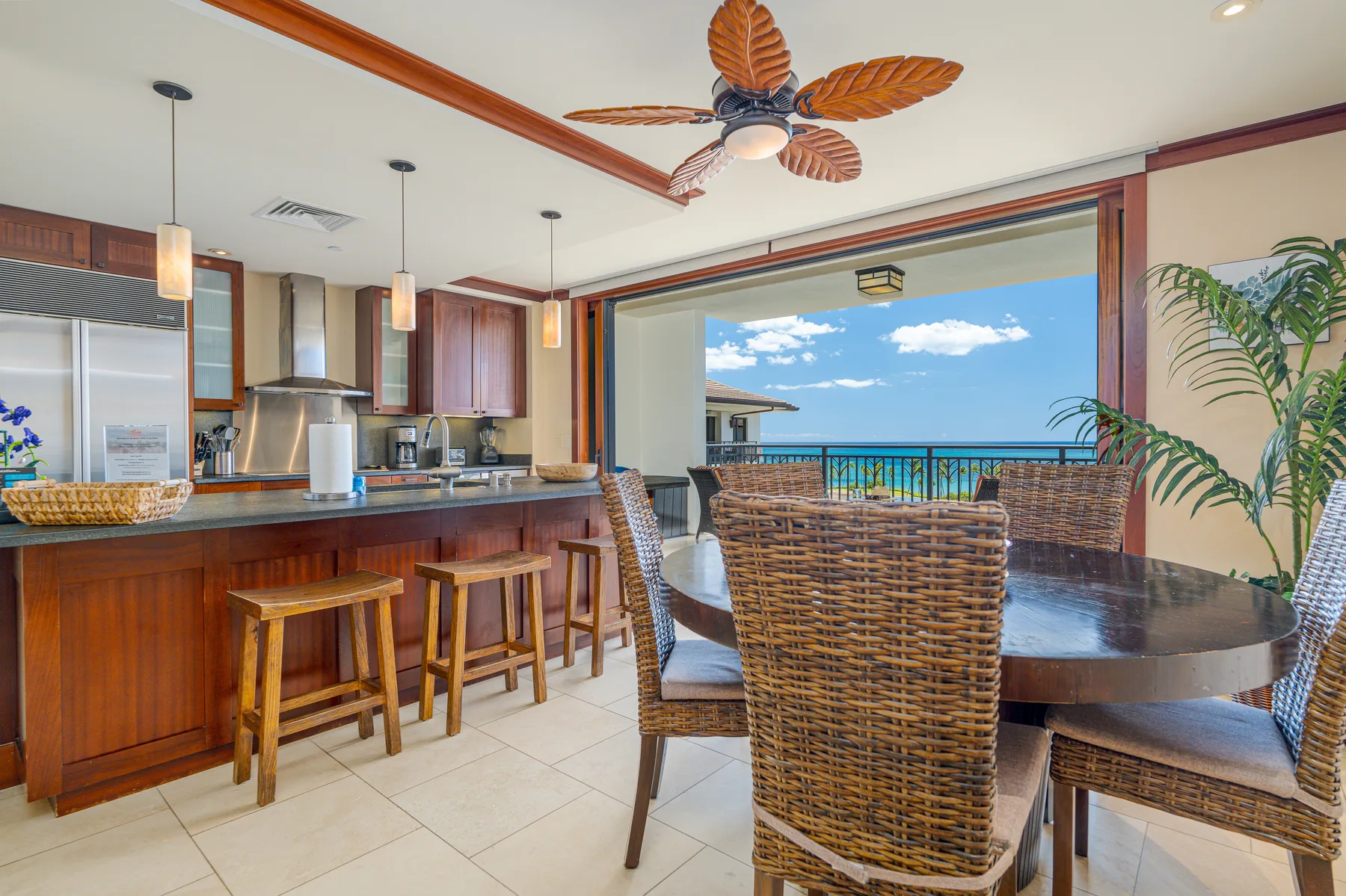 An open-plan dining and kitchen area with a table facing the ocean.