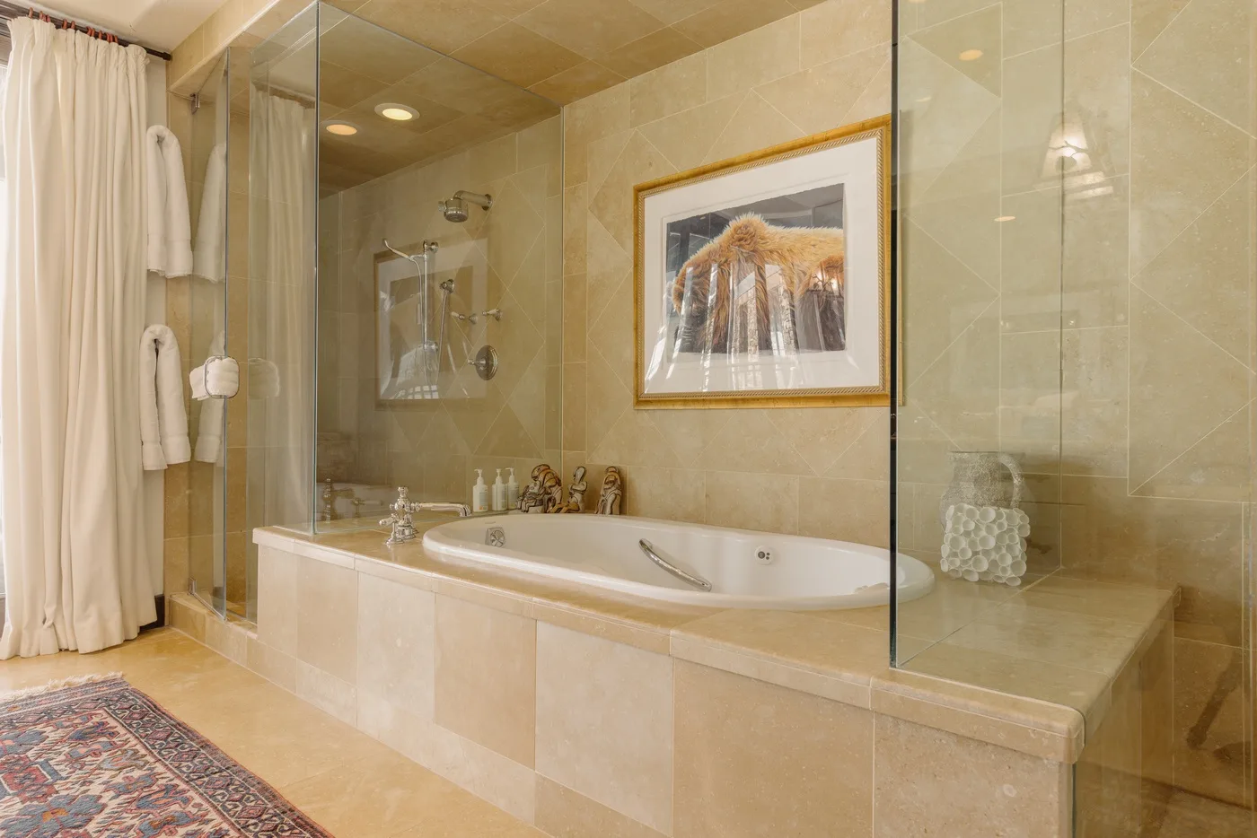 Un baño amplio con azulejos, bañera integrada y mampara de ducha de vidrio.