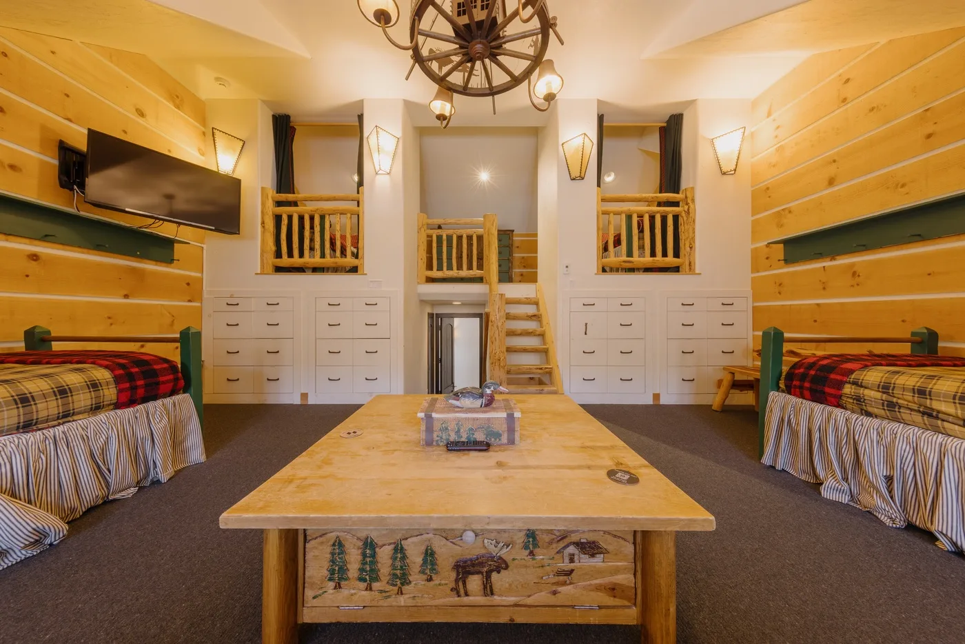 Un dormitorio revestido de madera con dos camas y una mesa central.