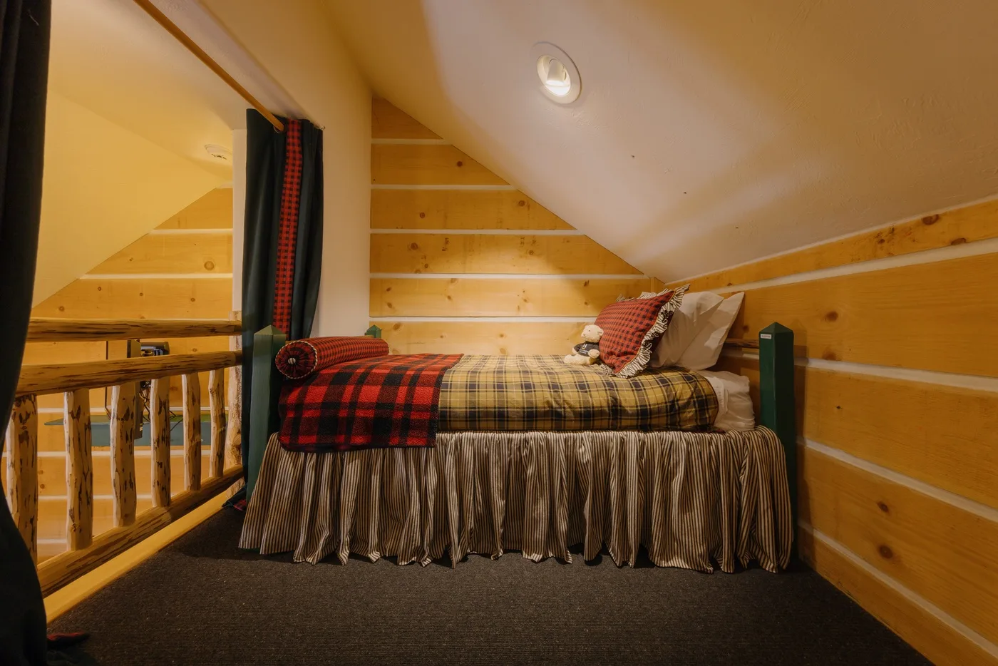 Un acogedor dormitorio en el ático con una cama bajo el techo inclinado.