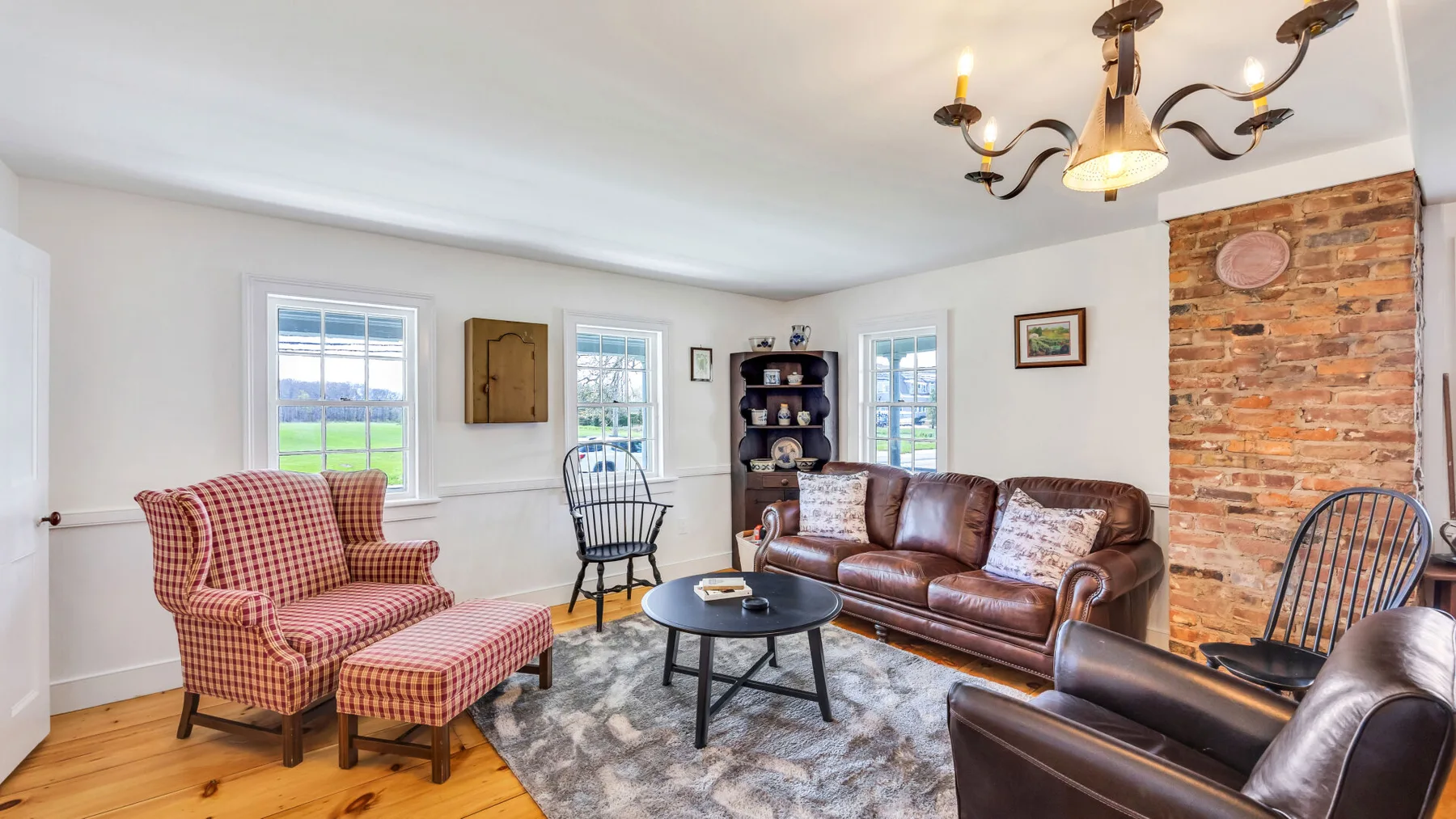A living room with patterned seating, a leather sofa, and a coffee table.