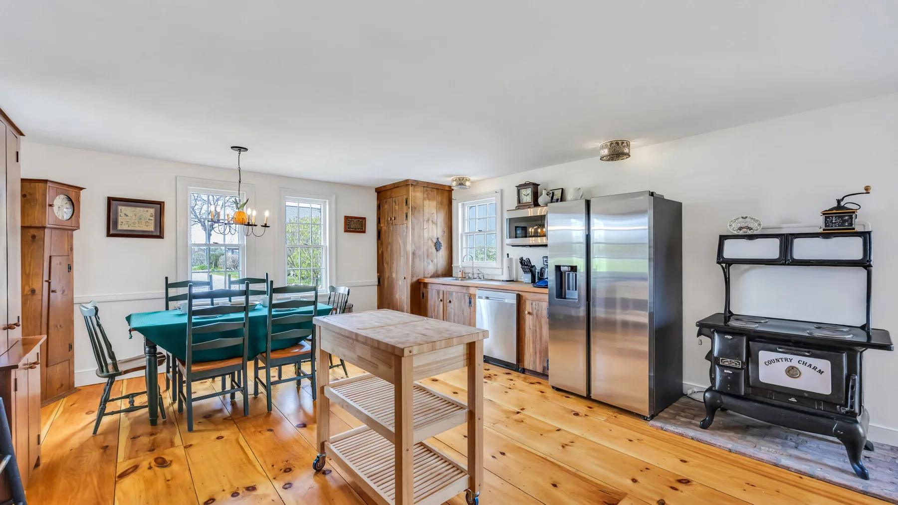 A kitchen and dining area with a wooden table and stainless steel appliances.
