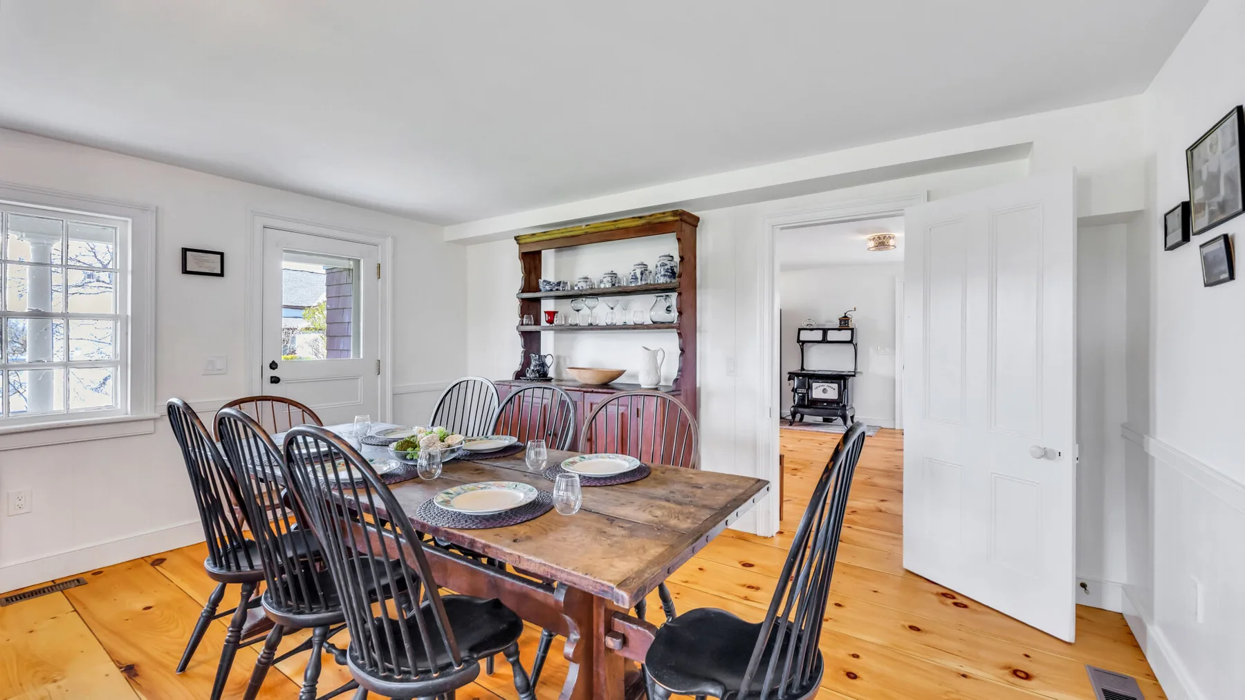 A bright dining room with a wooden table and black chairs.