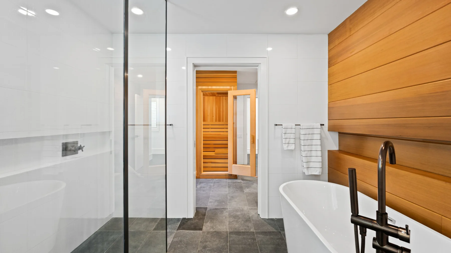 A modern bathroom with a glass shower and a freestanding bathtub.