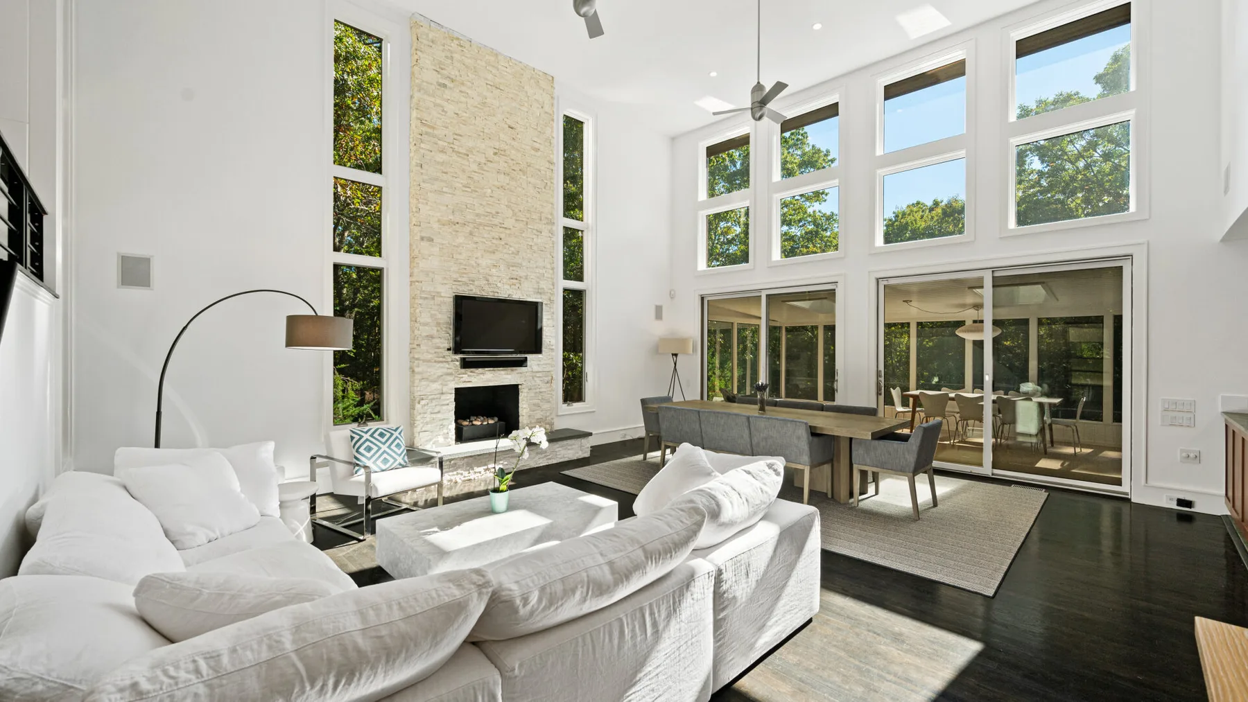 A bright living room with large windows and seating around a low table.