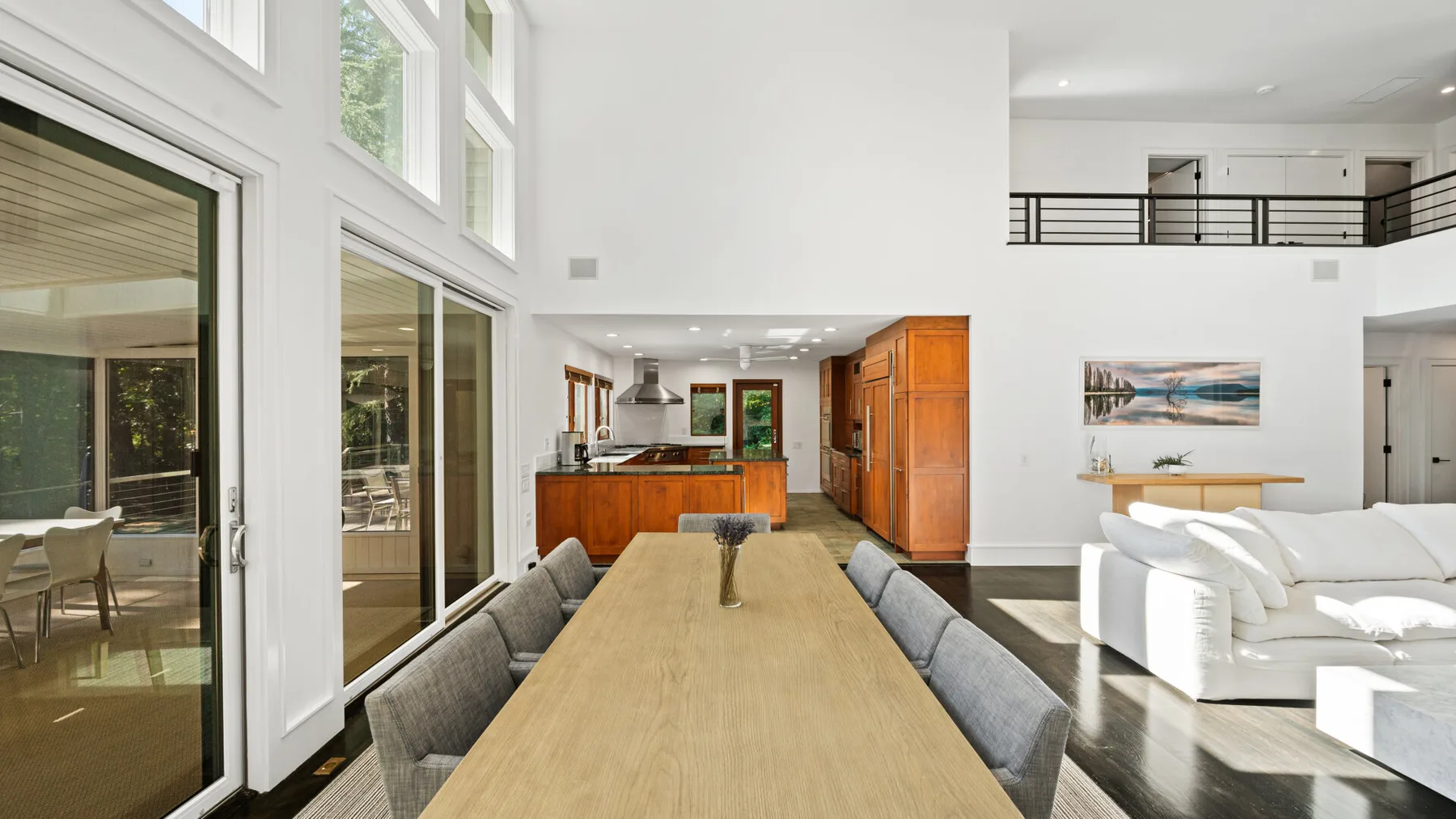 A bright open-plan living and dining area with a kitchen beyond.
