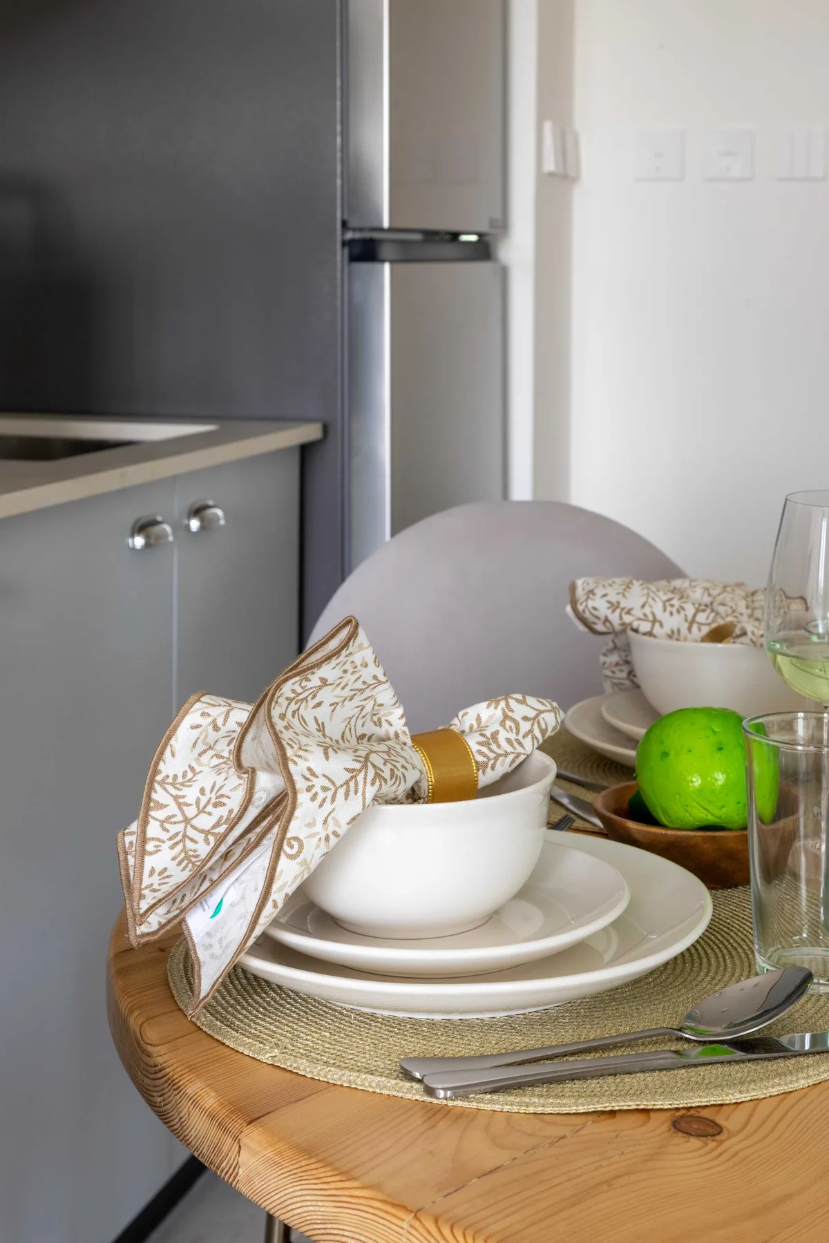 Una mesa puesta con platos y cuencos junto a una cocina moderna.
