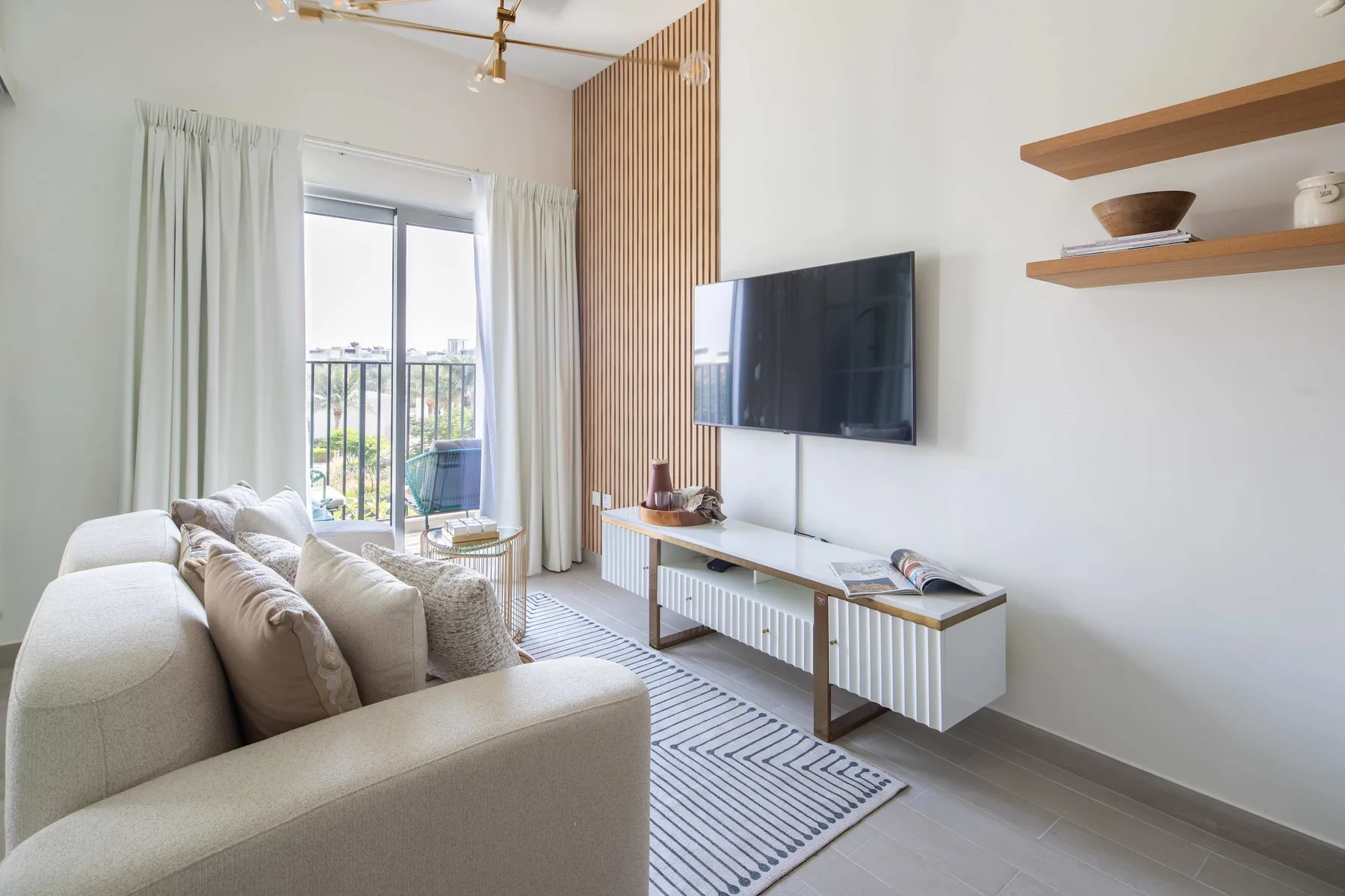 Una sala luminosa con asientos, un televisor y una ventana amplia.