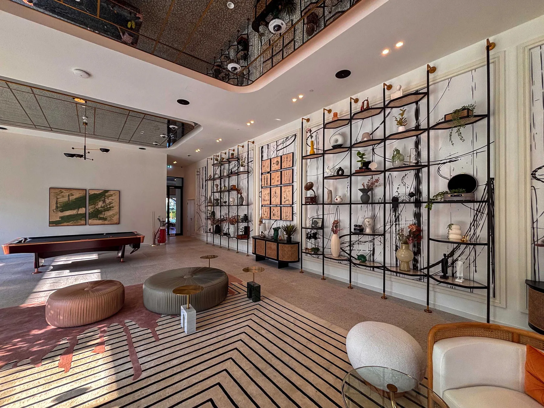 Una sala contemporánea con estanterías de exhibición, asientos bajos y suelo a rayas.