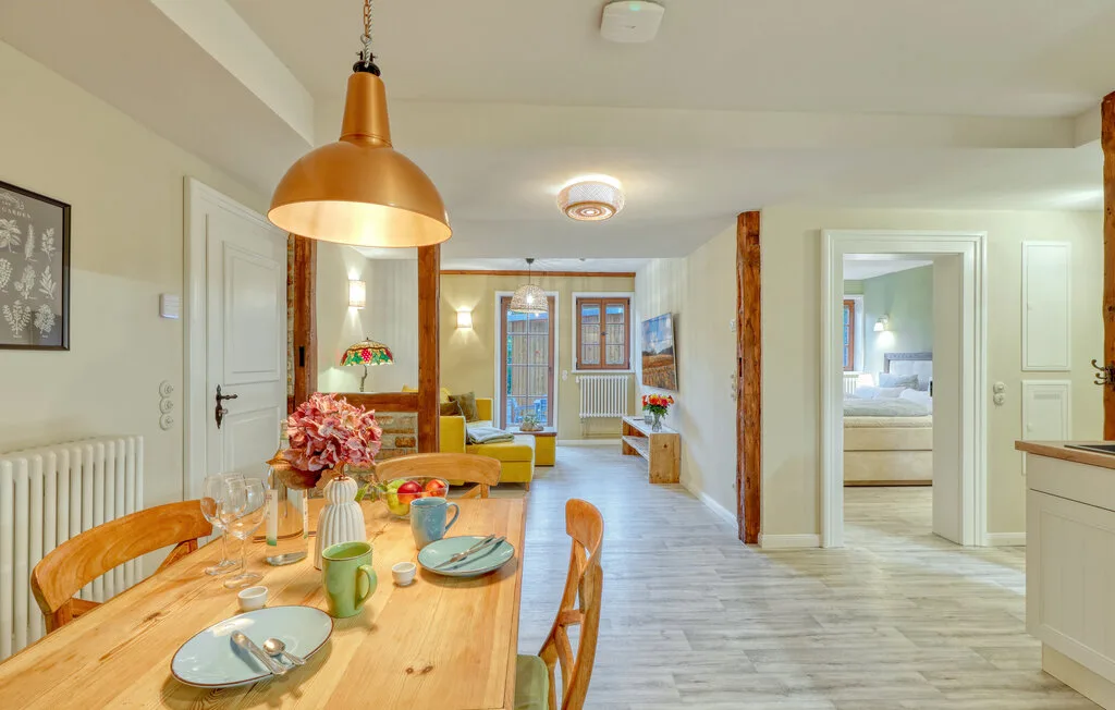 A dining area with a set table opens onto a bright living space.