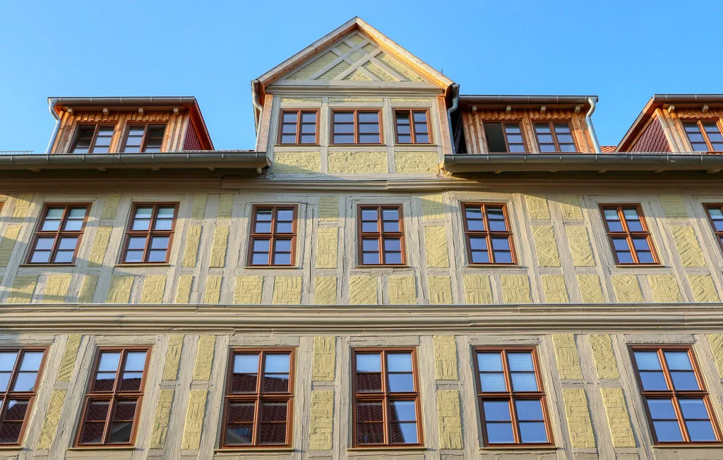 A multistory building facade with rows of windows and a prominent central gable.