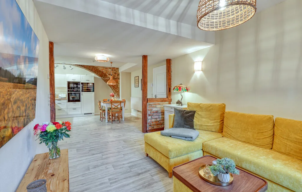 A bright living room with yellow seating and a dining area beyond.
