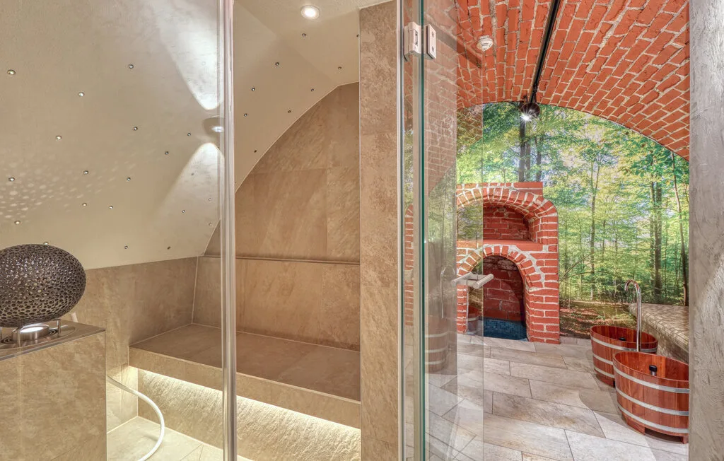 A tiled bathing area opens onto a brick alcove with a wooden tub.