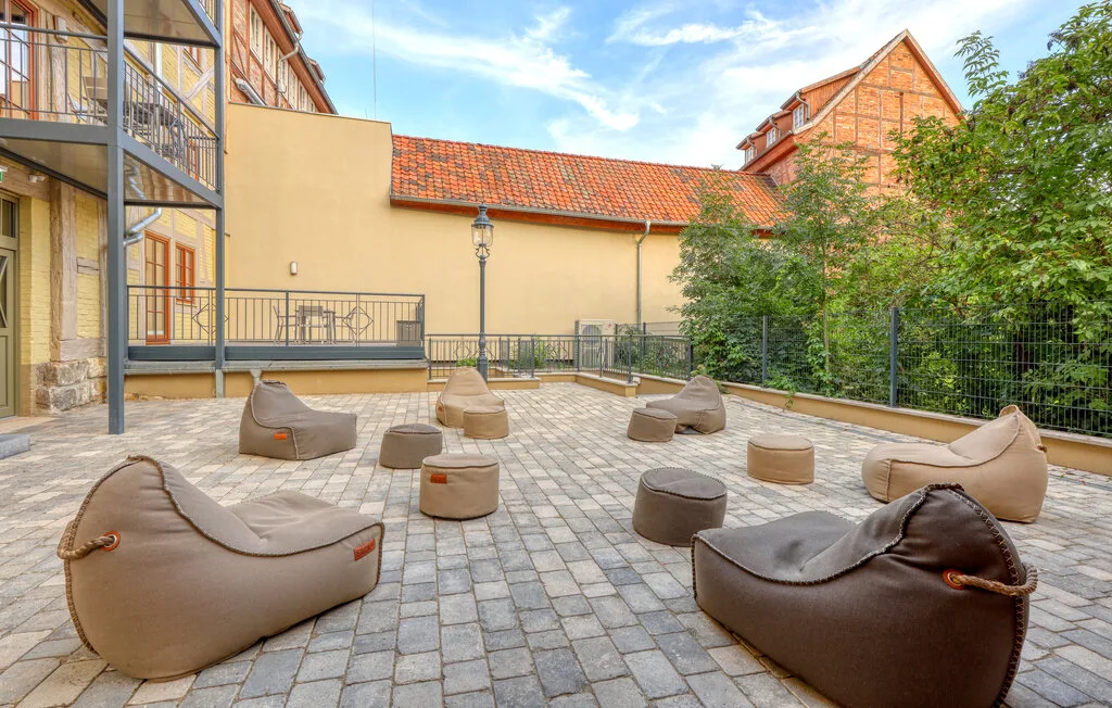 An outdoor paved terrace has casual seating arranged around the open space.