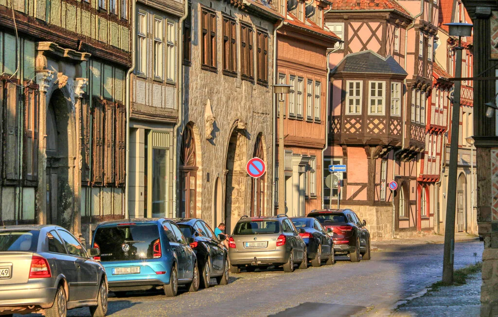 A street lined with historic-looking buildings and parked cars.