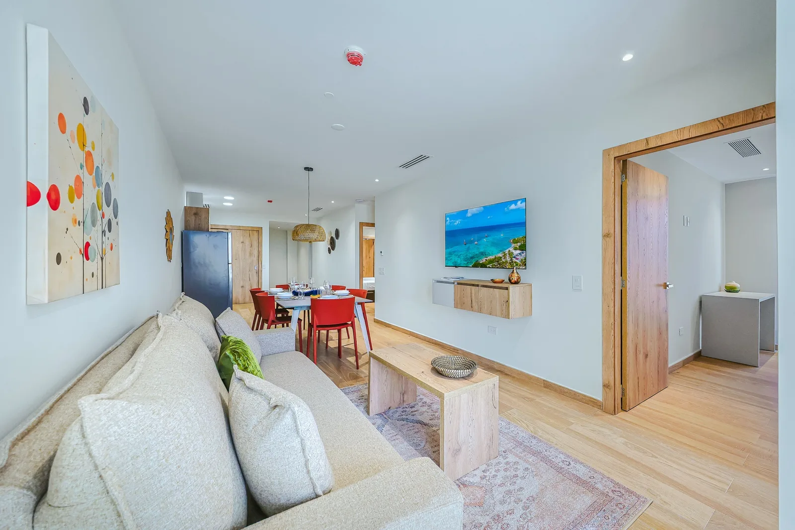 Settle into your bright, open living space where natural wood tones and airy design create an instant sense of calm. The plush sofa invites relaxation, while the adjacent dining area is ready for shared meals and laughter.