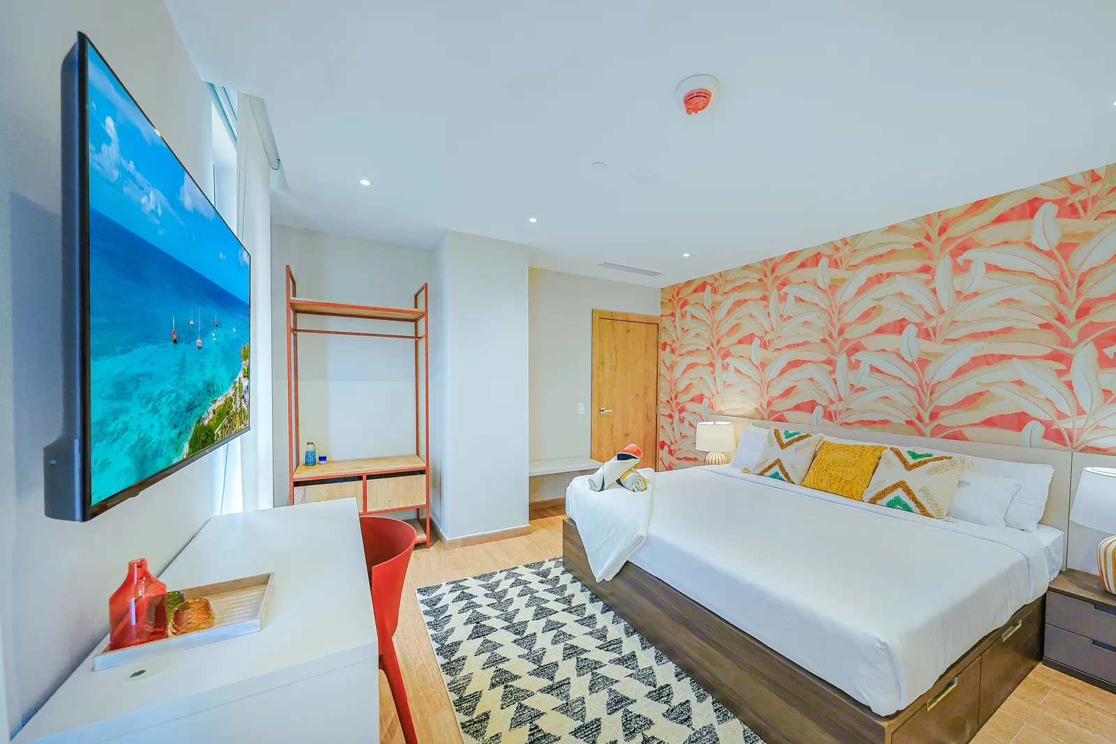 Sink into plush bedding and unwind in your colorful, contemporary retreat, complete with tropical-inspired accent wall and modern entertainment.