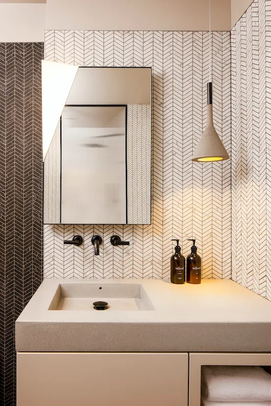 Baño de una habitación con azulejos estampados.