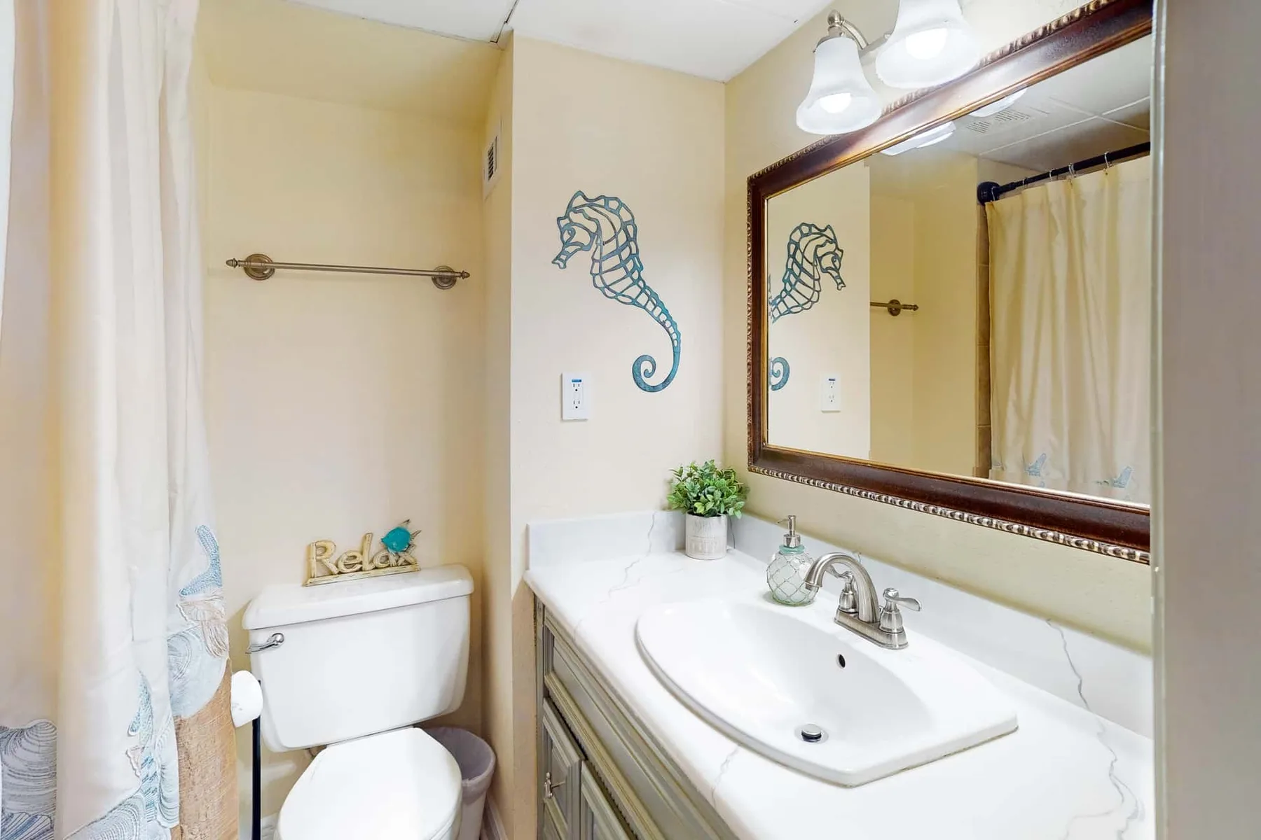 Un baño con lavabo, espejo y cortina de ducha.
