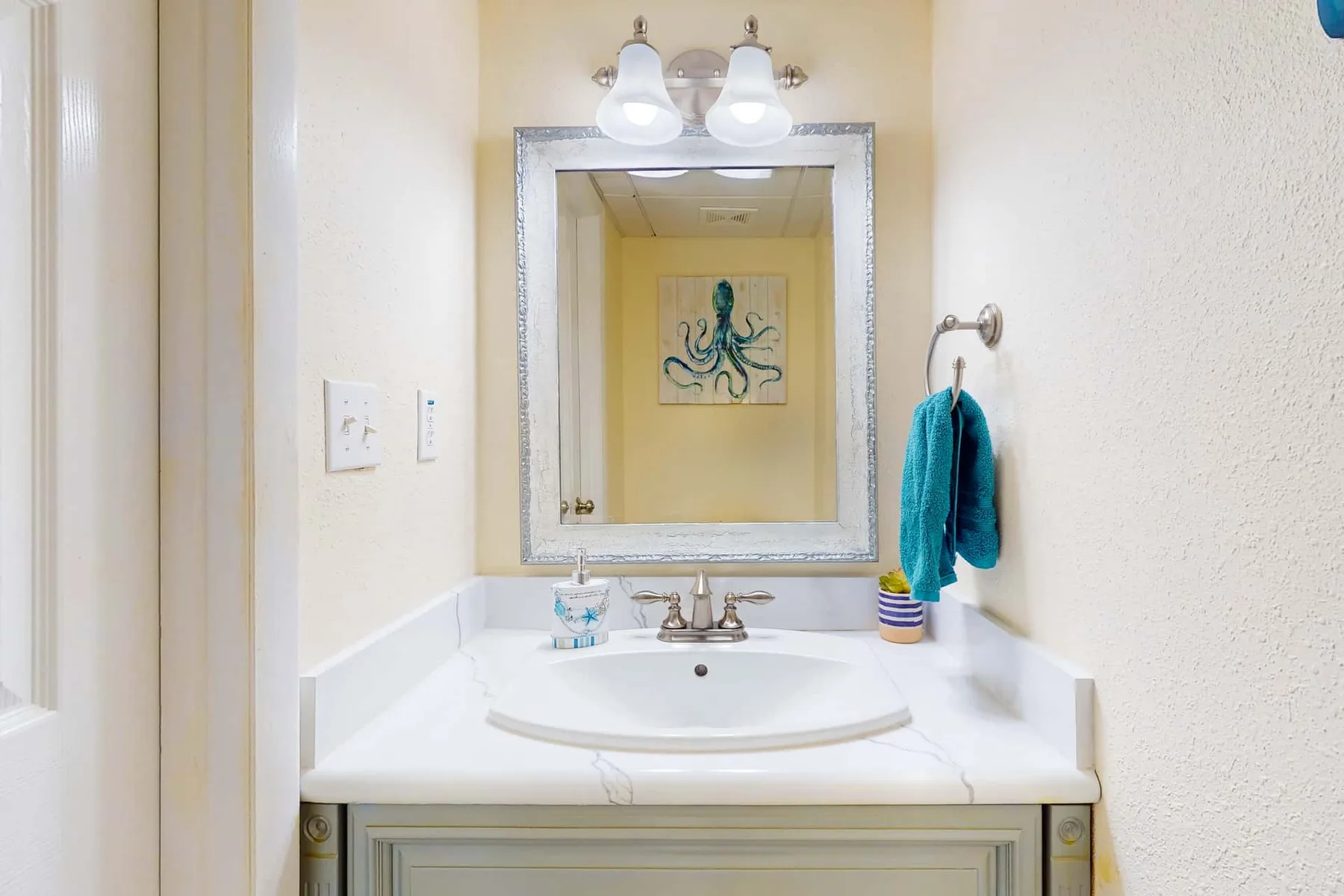 Un lavabo de baño con espejo y toallas color turquesa.