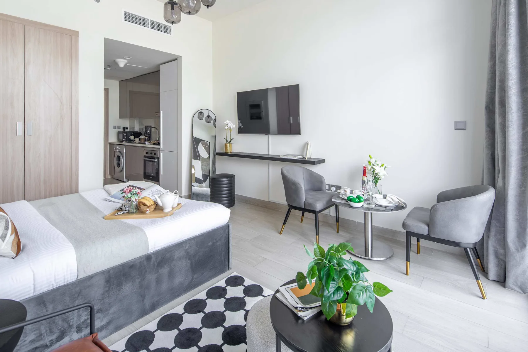 Dormitorio luminoso con cama, escritorio y zona de estar.