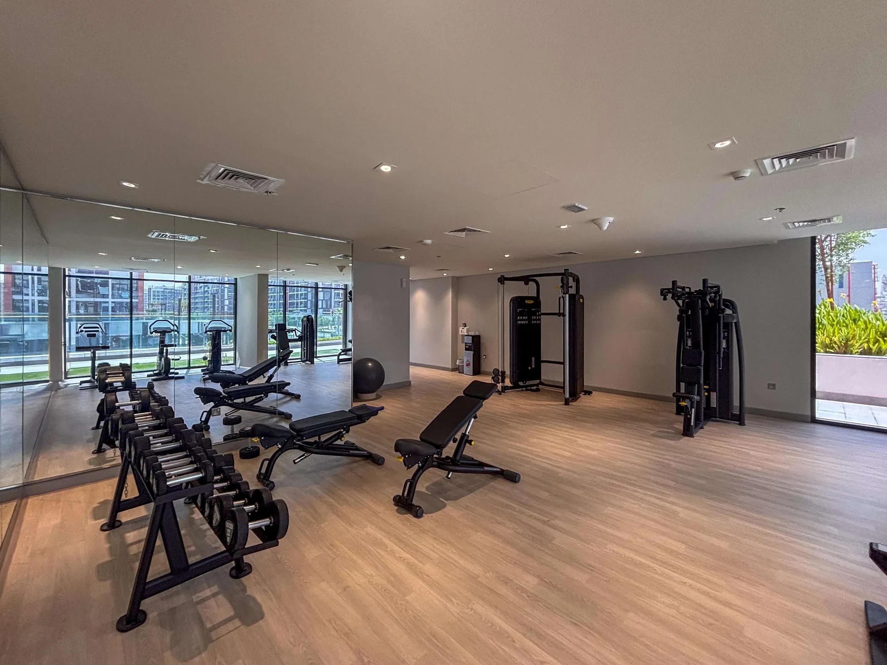 Una sala de fitness con máquinas de ejercicio, pesas y una pared con espejo.