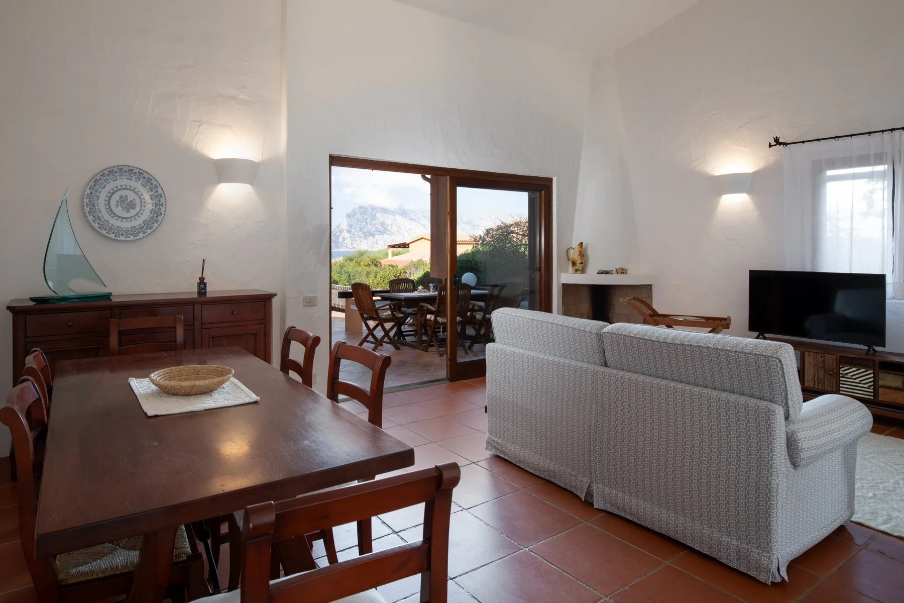 Una luminosa sala de estar y comedor se abre a un patio a través de puertas de vidrio.