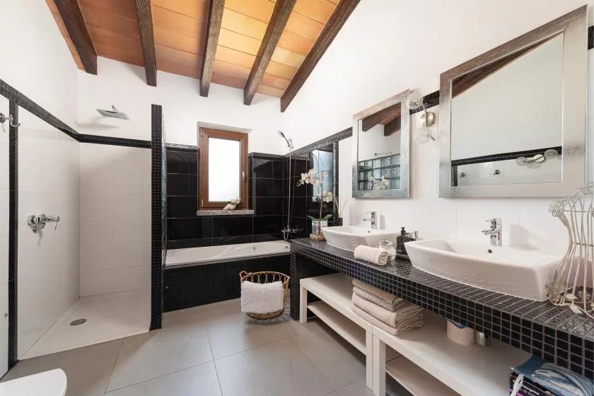 A spacious bathroom with a walk-in shower, bathtub, and double sinks.