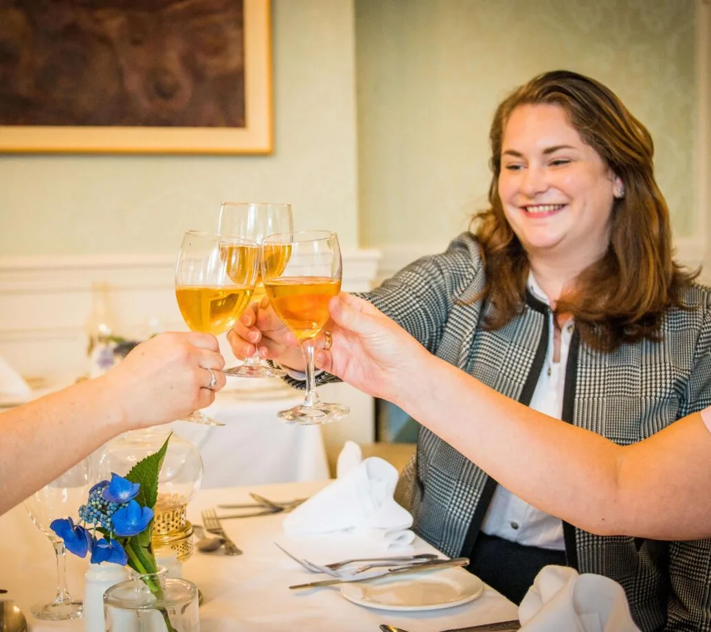 Huéspedes alzando sus bebidas en el comedor del hotel.