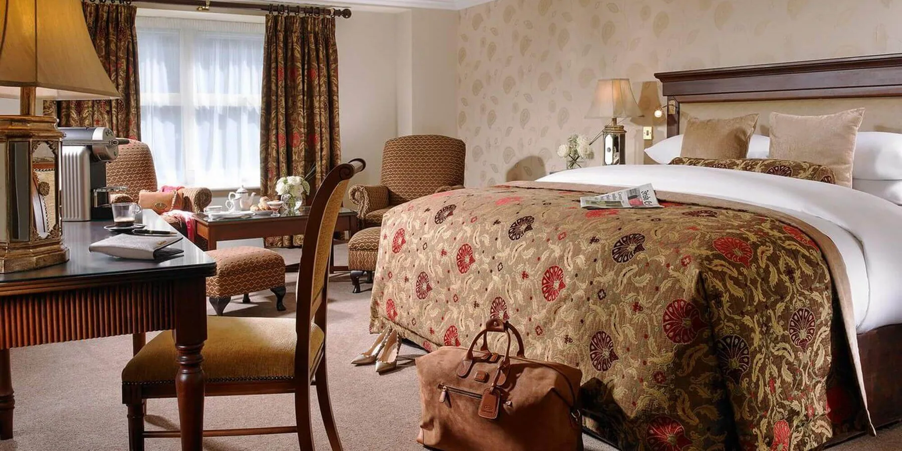 Habitación de hotel con una cama y sillas.