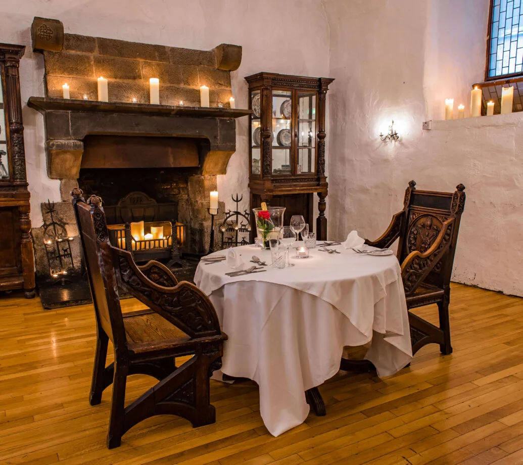 Comedor privado con una mesa para dos junto a una chimenea.