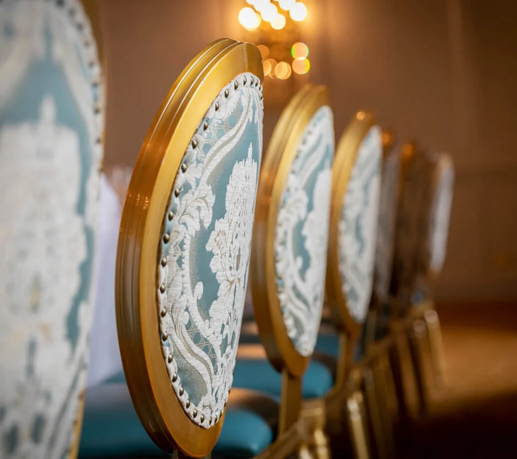 Sillas dispuestas en una sala de eventos del hotel con iluminación cálida.