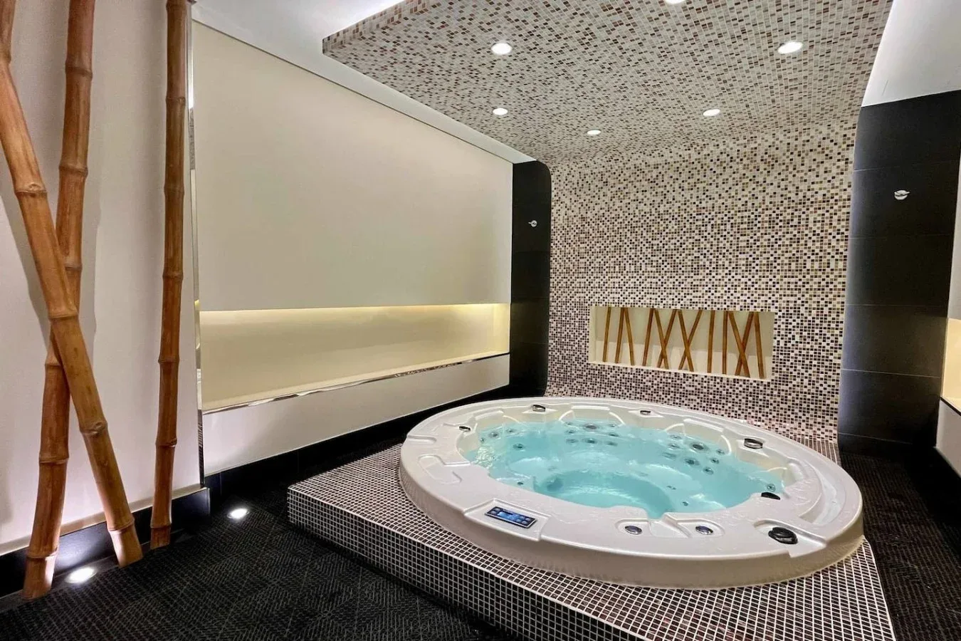 Un spa alicatado con una bañera de hidromasaje redonda y luces empotradas.