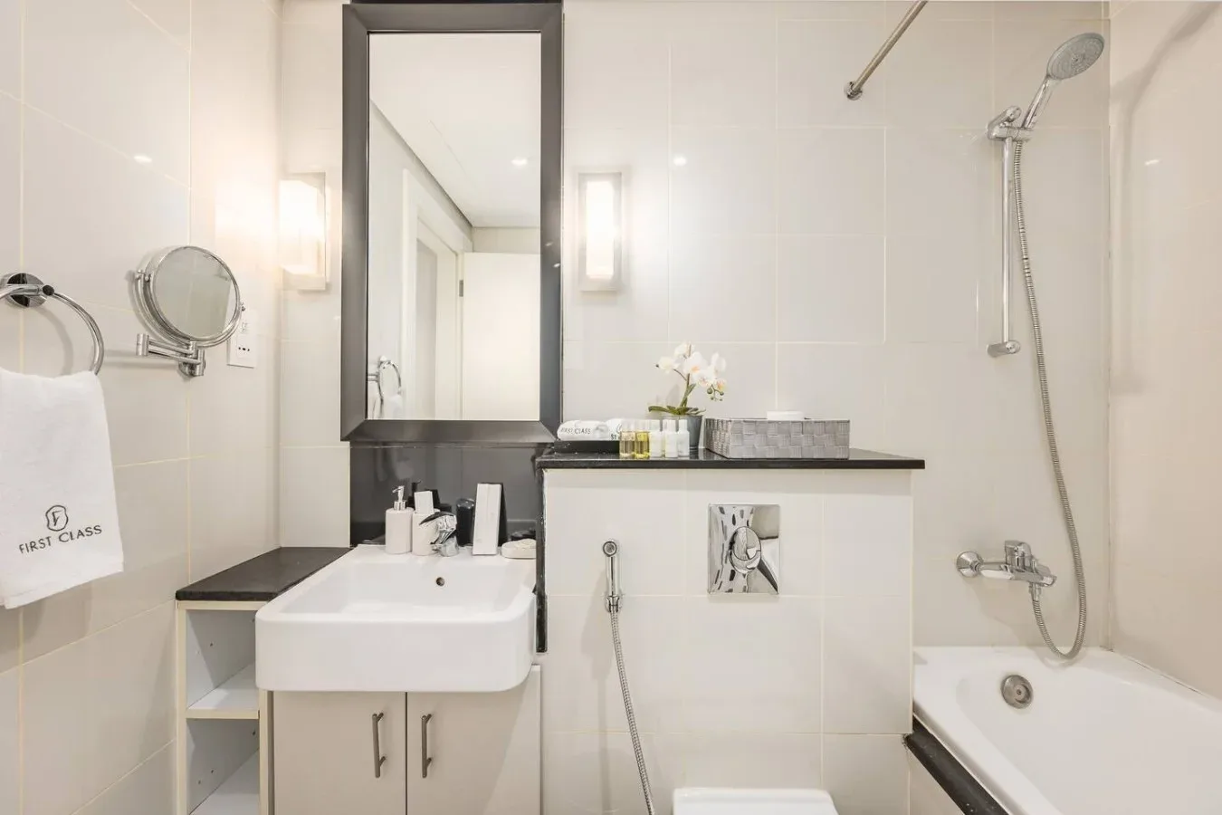 Un baño con azulejos, lavabo, espejo y bañera.