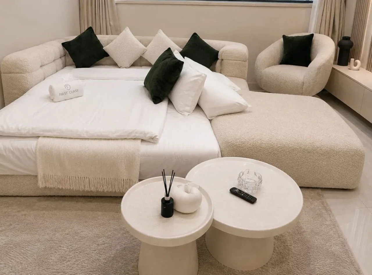 Una zona de descanso del dormitorio tiene una cama grande y dos mesas de centro redondas.