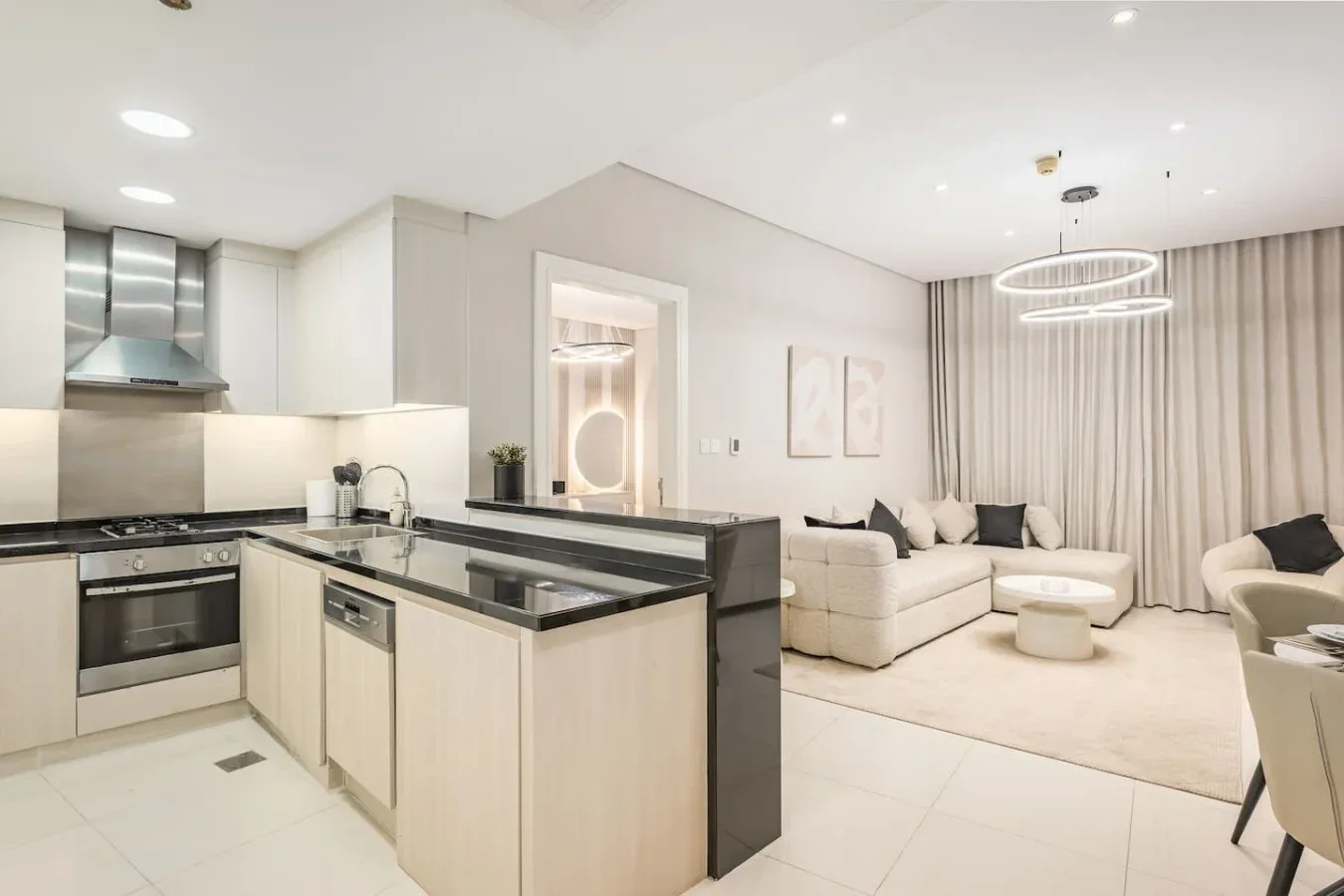 Cocina y sala de estar de concepto abierto con una zona de asientos clara.