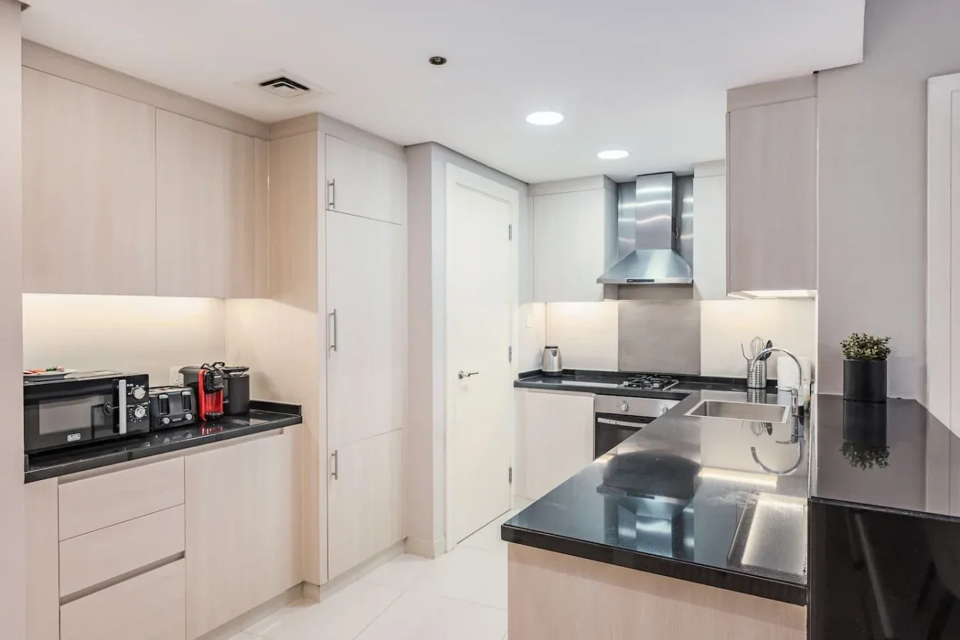 Una cocina moderna con gabinetes claros, encimeras oscuras y una isla central.