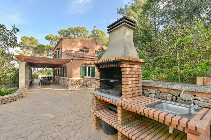Un patio exterior cuenta con una barbacoa de ladrillo y una encimera con fregadero.