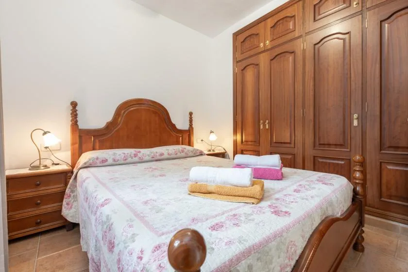 Un dormitorio con una colcha floral y armarios de madera.