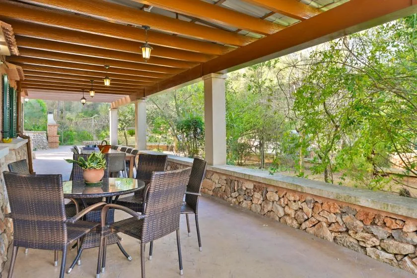 Un comedor exterior cubierto con una mesa y asientos alrededor.