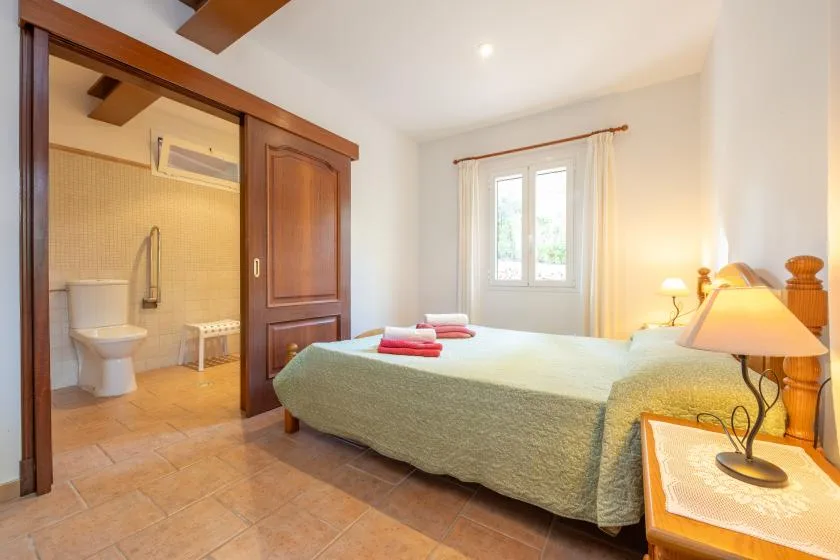 Un dormitorio con una cama grande junto a una zona de baño abierta.