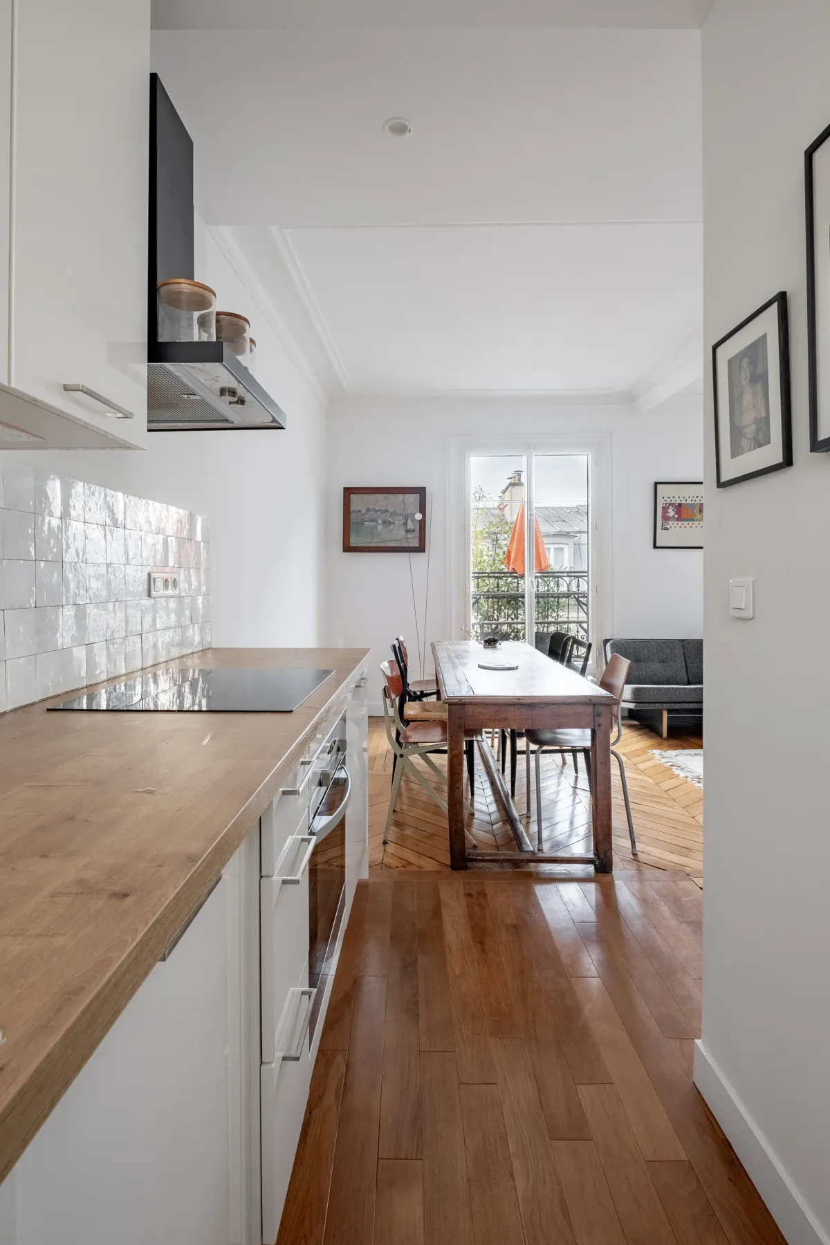 A bright kitchen and dining area with a long wooden table by the window.